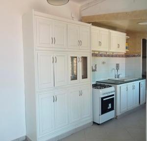a kitchen with white cabinets and a stove at Villa Dar Annette in El Mouradia