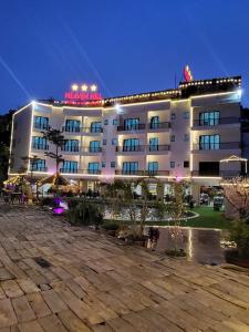 a hotel building with a courtyard at night at Heaven Hill Hotel & Hot Spring in Cham Ta Lao