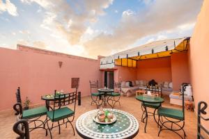 a patio with tables and chairs and a living room at Riad Privé Dar L'Étoile - Jacuzzi Piscine & Petit Déj inclus in Marrakech