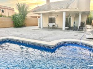 una piscina frente a una casa en CHALET CON PISCINA A 100m DE LA PLAYA LA MANGA en La Manga del Mar Menor