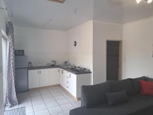 sala de estar con sofá y cocina en Partridge Place, en Kempton Park