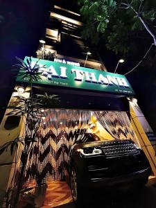 GRAD Dai Thanh Hotel في هانوي: سيارة متوقفة تحت لافتة على جانب مبنى