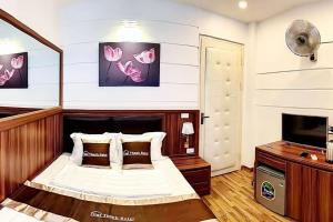 a bedroom with a bed and a flat screen tv at Dai Thanh Motel in Hanoi