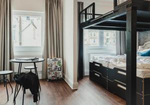 ein Schlafzimmer mit einem Etagenbett mit einem Tisch und einem Tisch in der Unterkunft Pyjama Park St. Pauli in Hamburg