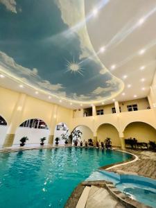 a large swimming pool in a building with a ceiling at Quê Tôi 2 Hotel in Soc Trang