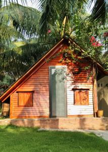 a small house with a window and a palm tree at Phu Nam House - Resort in Phú Quốc