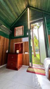 a bedroom with a bed and a large window at Phu Nam House - Resort in Phú Quốc