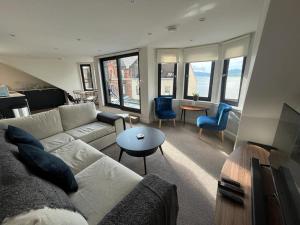 uma sala de estar com um sofá e uma mesa em Crow’s Nest, Waverley Apartments em Gourock