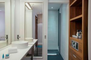 a bathroom with two sinks and a mirror at Aloft Liverpool in Liverpool
