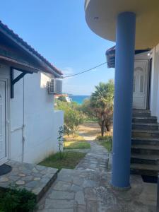 a house with a blue pole next to a door at Blue Bay Beach Hotel in Koinyra