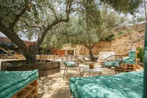 a patio with chairs and tables and a tree at El Maestrazgo in Xert