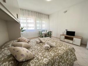 Schlafzimmer mit einem Bett mit Kissen und einem Tisch in der Unterkunft Imperiale Apartment in Tirrenia