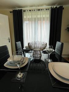 un comedor con una mesa con copas de vino en Majestic House - Milton Keynes Serviced Accommodation, en Milton Keynes