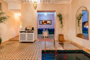 a living room with a pool in the middle of a room at Riad Privé Dar L'Étoile - Piscine & Petit Déj inclus in Marrakesh