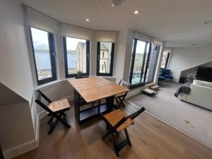 uma sala de estar com uma mesa e cadeiras e um sofá em Crow’s Nest, Waverley Apartments em Gourock
