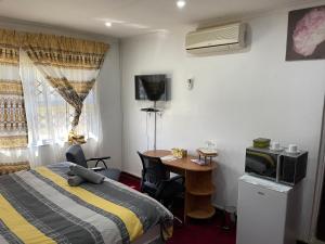 a hotel room with a bed and a desk with a microwave at AGASTEV GUESTHOUSE in Springs