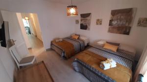 a room with two beds and a chair in it at AbumaHouse in Los Llanos de Aridane