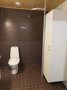 - une salle de bains avec des toilettes blanches dans une cabine dans l'établissement Kotimaailma Apartments Vapaudenkatu 48-50 B3, à Jyväskylä