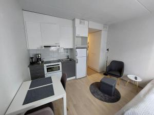 een kleine keuken met een tafel en stoelen in een kamer bij Kotimaailma Apartments Vapaudenkatu 48-50 B3 in Jyväskylä