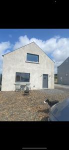 a white building with a bench in front of it at Island View Apartment in Droíchead an Chláir