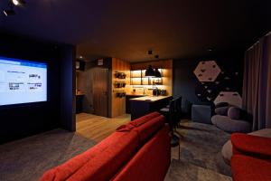 a living room with a red couch and a projection screen at Apartmán Volavka in Hlinsko