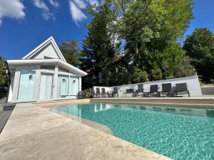 a swimming pool with chairs next to a house at Tiétek a HÁZ in Mogyoród