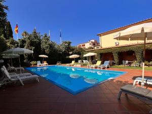 une grande piscine avec des chaises et des parasols dans l'établissement Residence Il Gabbiano Azzurro, à Marciana Marina