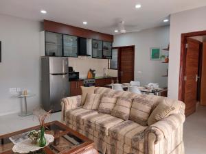 een woonkamer met een bank en een keuken bij Aqua View Apartments in Bijilo