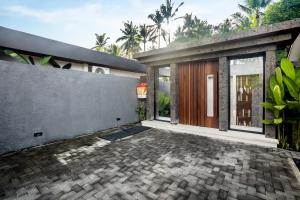 une terrasse d'une maison avec un mur et une porte dans l'établissement Sarang Cocoon Villa Ubud by BaliSuperHost, à Ubud