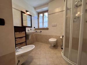 een badkamer met een wastafel, een toilet en een douche bij Trilocale Giustino Vadaione in Giustino