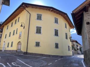 a large yellow building with a brown roof at Trilocale Giustino Vadaione in Giustino