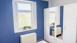 a blue bathroom with a toilet and a window at Berzi Ferienwohnung 001 Görlitz in Markersdorf