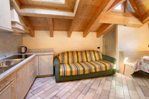 a kitchen with a couch in the middle of a room at Appartamento 8 in Livigno +15 photos