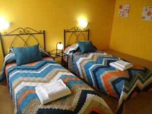 Casa Rural Escapada Rústica Teruel في تيرويل: سريرين يجلسون بجانب بعض في غرفة