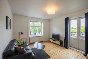 ein Wohnzimmer mit einem Sofa und einem TV in der Unterkunft Central Lyngby Apartments in Kongens Lyngby