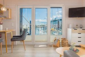 a living room with a view of a marina at Hausboot - Svanehus in Heiligenhafen