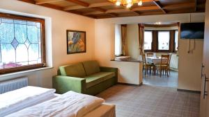 a hotel room with a bed and a couch and a table at Gasthof Pension Madseiterhof in Tux