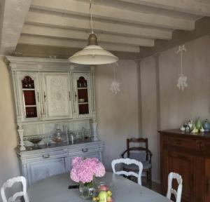 een keuken met een tafel met roze bloemen erop bij La Closeraie Saint-Girons Le Gîte in Saint-Girons-dʼAiguevives