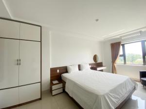 1 dormitorio con cama blanca y ventana en Ruby Hotel - near Thai Nguyen University en Thái Nguyên