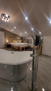 a bathroom with a bath tub and a bedroom at Hotel Stefani in Sibiu