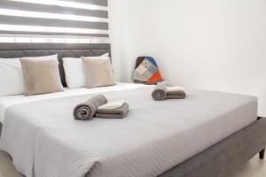 a large white bed with towels and pillows on it at Central Larnaca Apartment in Larnaca