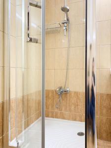 a shower with a glass door in a bathroom at Central Larnaca Apartment in Larnaca