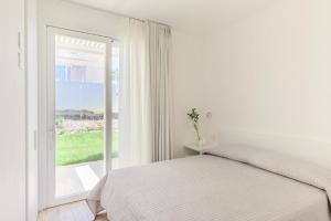 a white bedroom with a bed and a window at Stunning Capo Falcone Charming Apartments num1362 in Stintino