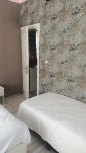 1 dormitorio con 2 camas y pared de ladrillo en Fetih Suite Home A1 en Estambul