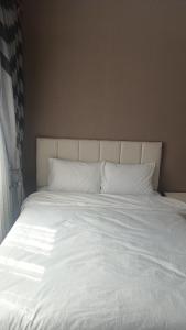 een groot wit bed met witte lakens en kussens bij Fetih Suite Home A1 in Istanbul