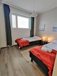a room with two beds and a window at Kotimaailma - Tyylikäs 3MH asunto Espoossa in Espoo