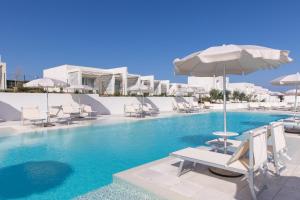 a swimming pool with chairs and an umbrella at Stunning Capo Falcone Charming Apartments num1362 in Stintino