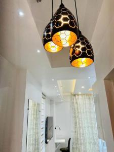 two lights hanging from the ceiling in a bathroom at EzyStay Boutique Suites in Lucknow