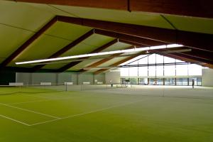 a tennis court in a building with lights on it at laVital Sport- & Wellness Hotel in Wesendorf