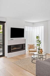 Una sala de estar con chimenea y televisión. en Iluka on the Avenue- 3 bedroom, 2 bathroom. Brand new. 150m walk to shops, en Ocean Grove